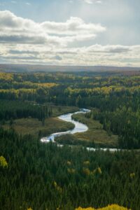 Aerial image of Lake Superior Hiking with river in the middle and green evergreen trees. Photo by Cameron Peters